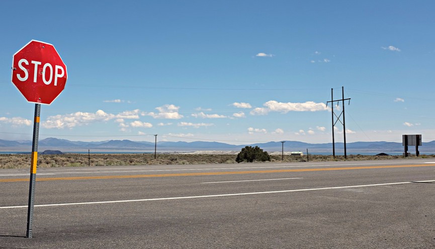 stop sign on empty road in desert
