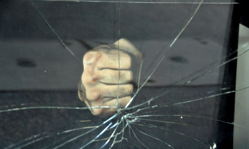 fist breaking a pane of glass