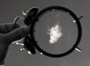 holding a hollowed-out clock up to the sky to capture a cloud within the body
